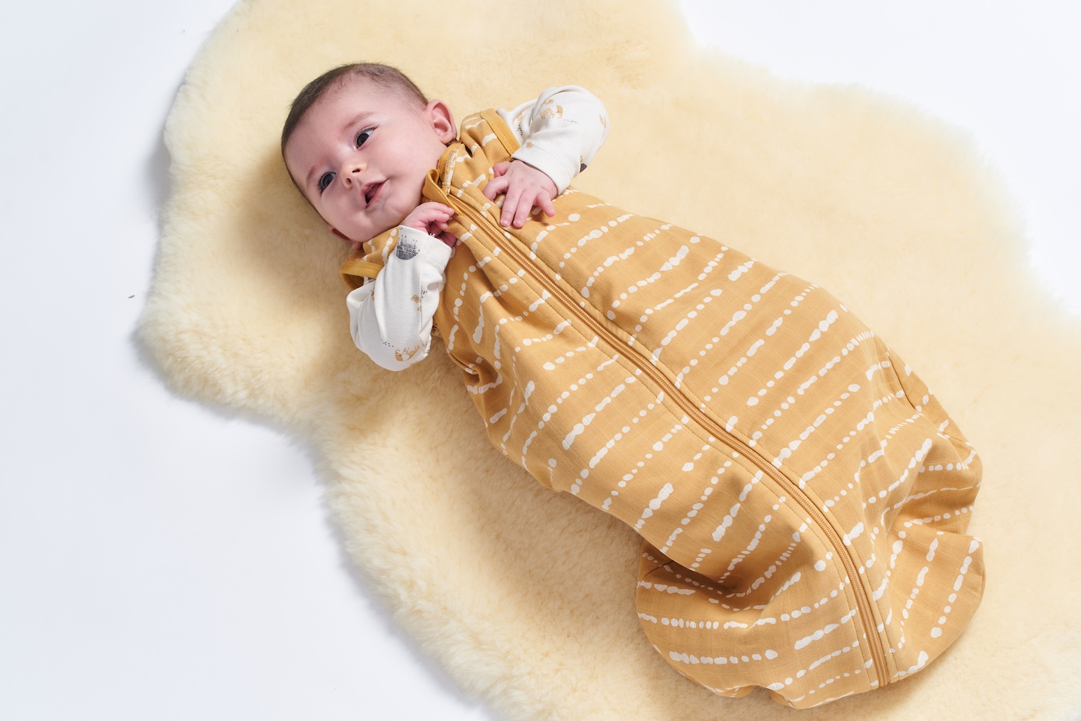 Baby im Schlafsack auf Lammfell
