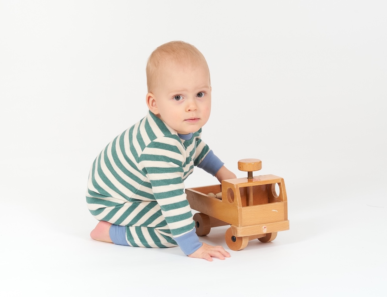 Baby  spielt mit Unimog aus Holz
